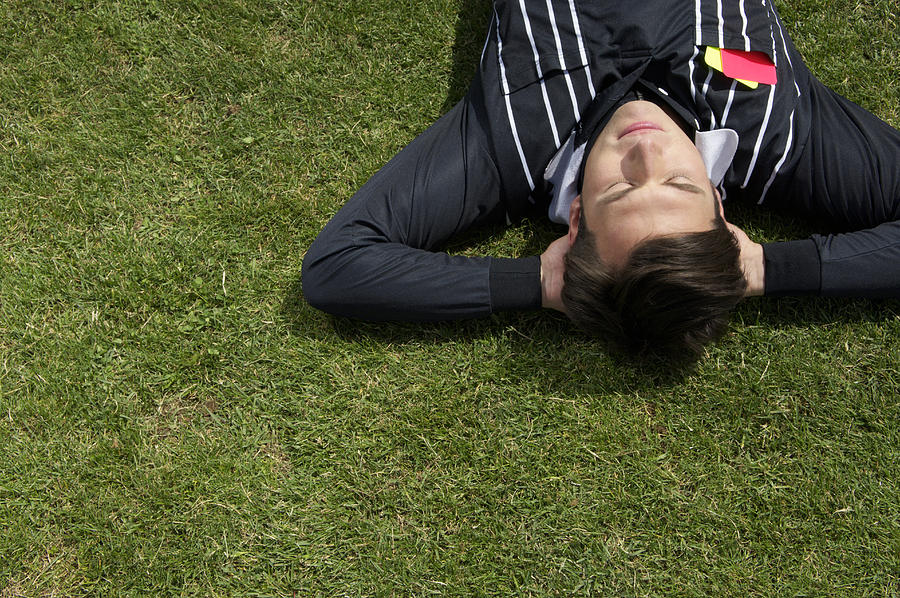 Relaxed referee lying on soccer field Photograph by Stock4b-rf