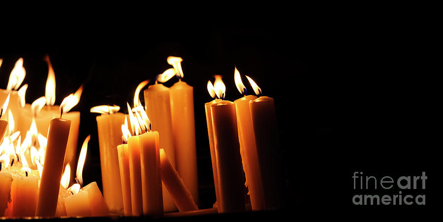 Religious candles on black background. Yellow candlelight f Photograph by Jelena Jovanovic