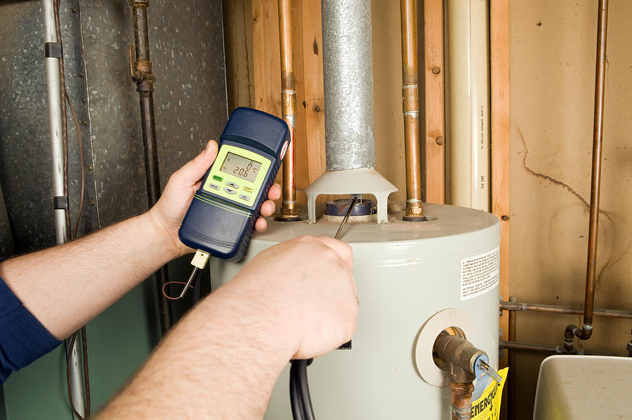 Repairman Checks Carbon Monoxide Level on Gas Water Heater Exhaust Photograph by BanksPhotos