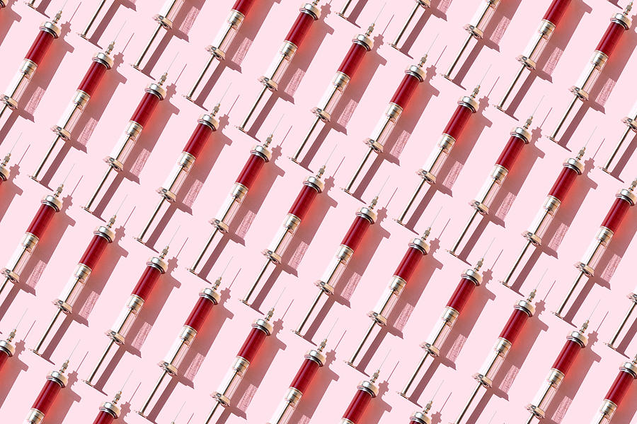 Repeated of blood in syringes on the pink background Photograph by Yulia Reznikov