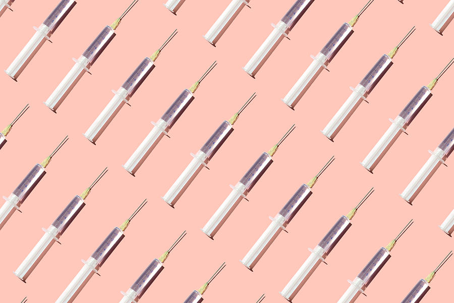 Repeated syringes on the pink background Photograph by Yulia Reznikov