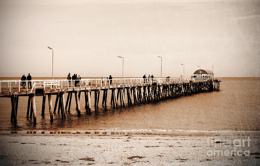 Retro grunge vintage style sepia people on jetty pier boardwalk. Photograph by Milleflore Images