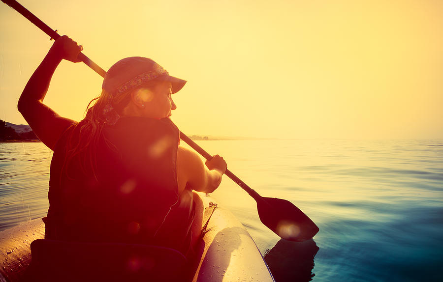Riding a kayak on sea at sunset Photograph by IvanJekic