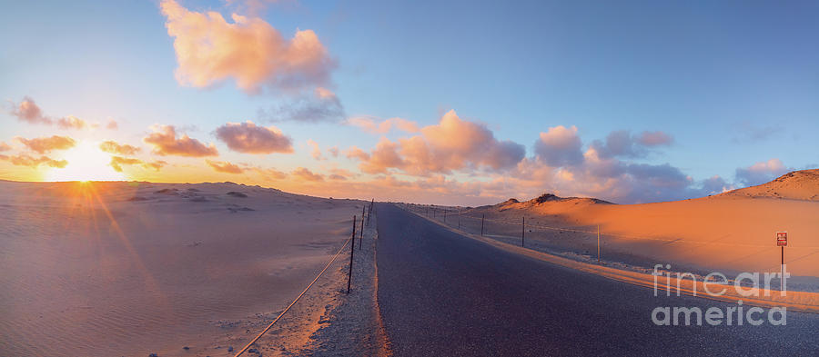 Road through sand dunes at sunset Photograph by Hanna Tor