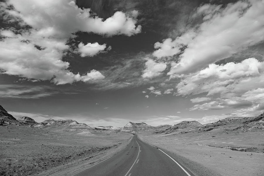 Road with clouds at Theodore Roosevelt National Park in North Dakota in black and white Photograph by Eldon McGraw
