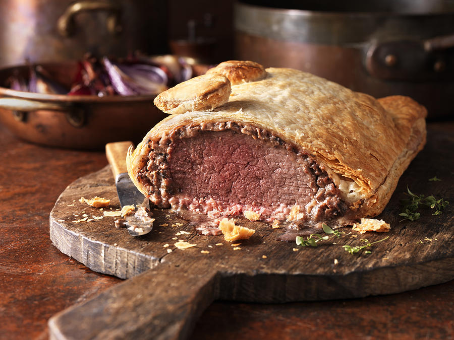 Roast beef wellington, red onions in background, fresh thyme Photograph by Diana Miller