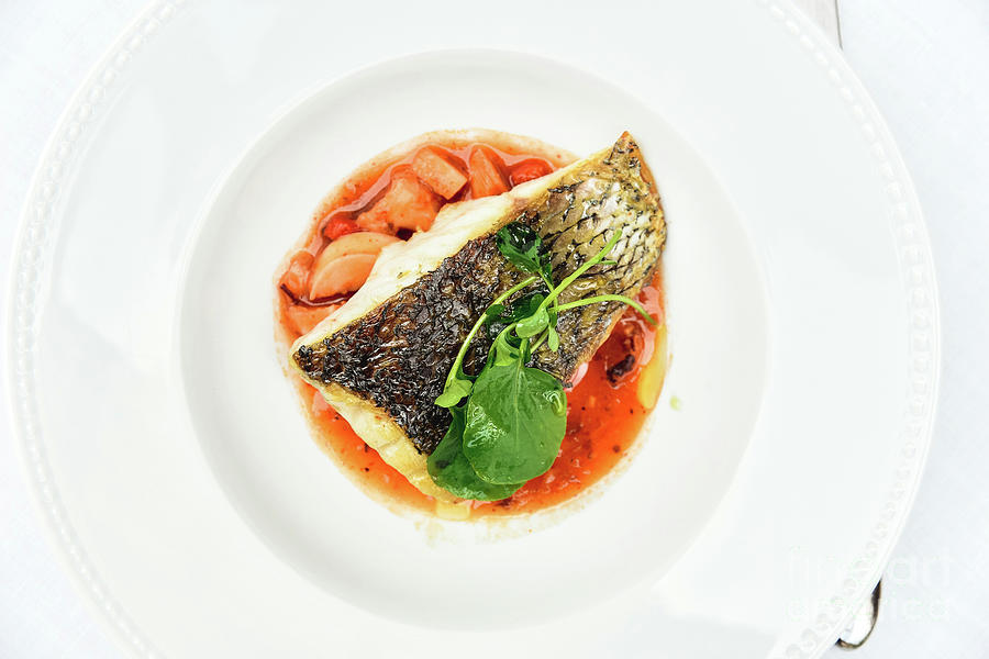 Roasted Sea Bass served on a white plate rich in healthy fatty acids from fish. Photograph by Joaquin Corbalan