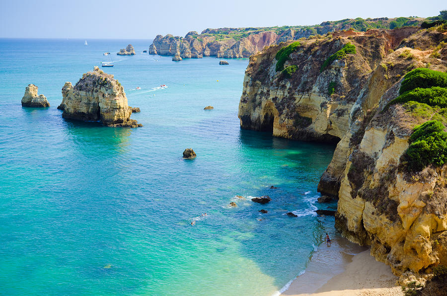 Rock cliffs bordering a teal sea in Lagos, Algarve, Portugal Photograph by Gregobagel