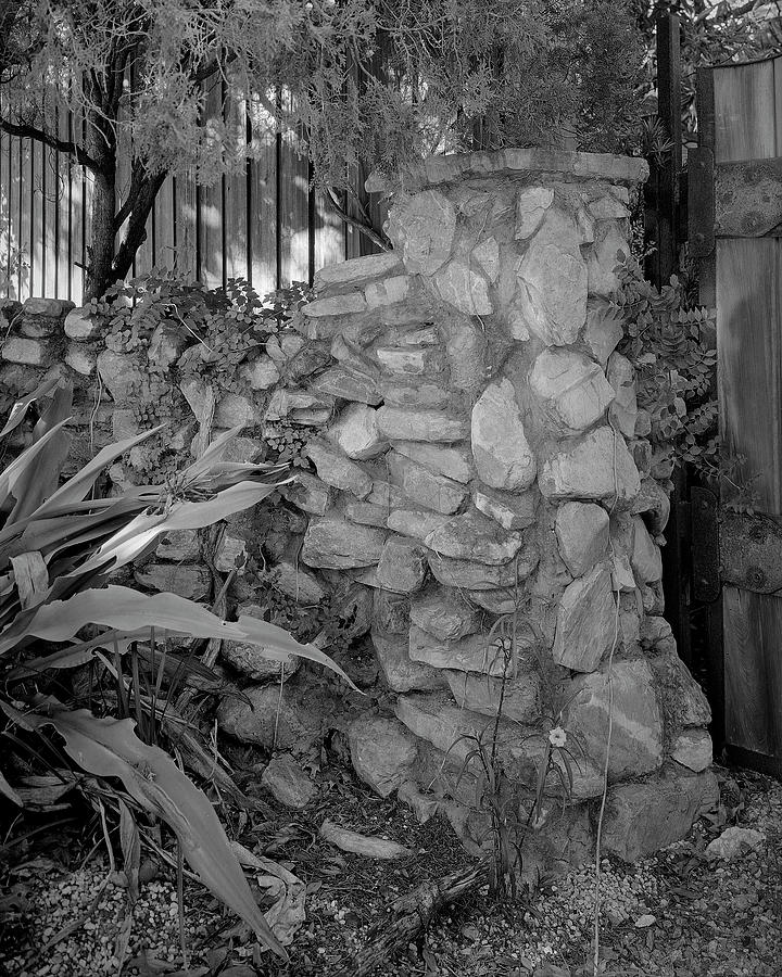 Rock wall and gate Photograph by John Simmons