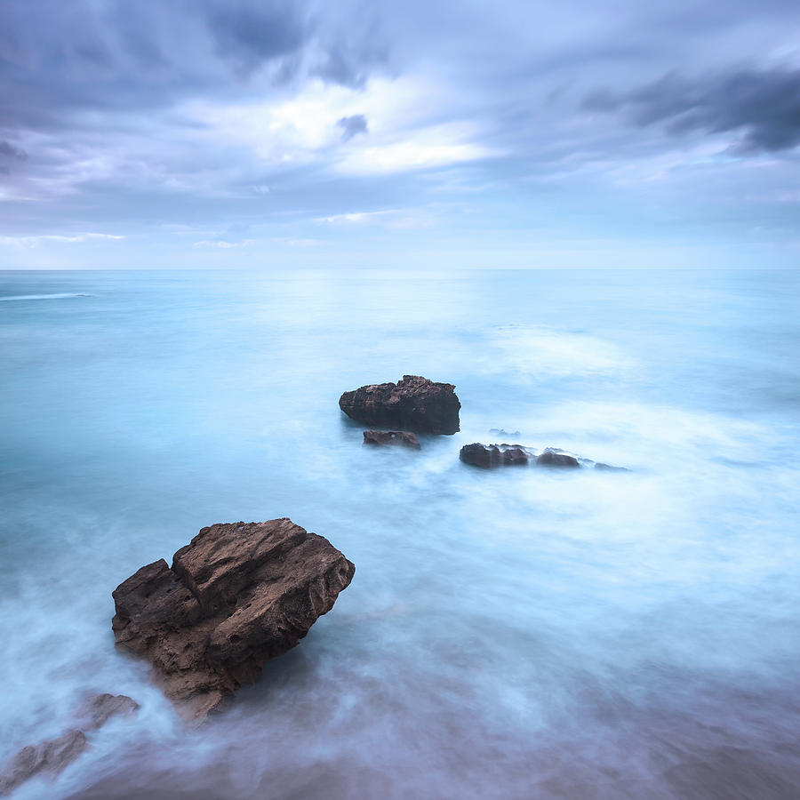 Rocks in a ocean waves under cloudy sky. Bad weather. Photograph by Stefano Orazzini