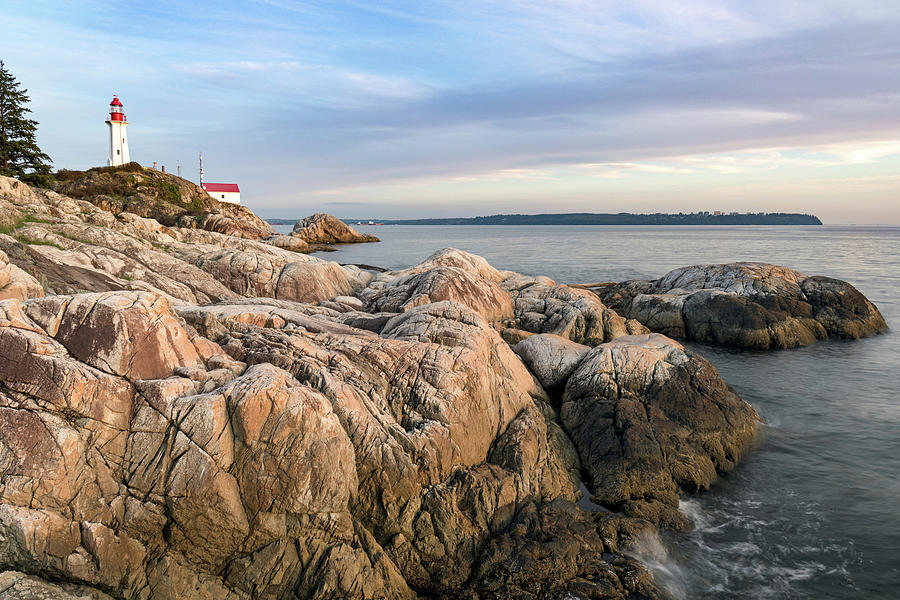 Rocky shoreline and the Point Atkinson Lighthouse Photograph by Michael Russell