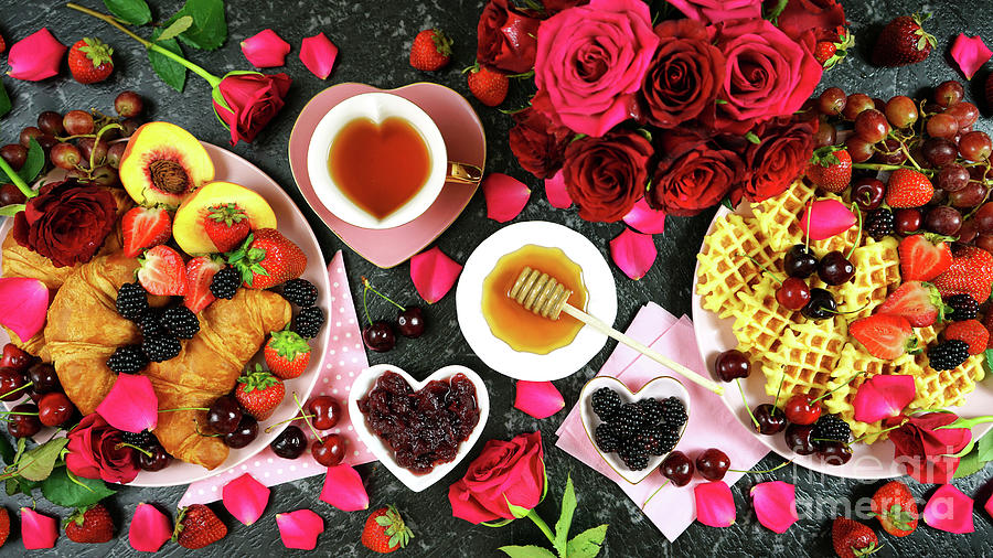 Romantic indulgent breakfast with croissants, pancakes, waffles fruit and roses. Photograph by Milleflore Images
