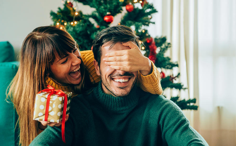 Romantic young couple exchanging Christmas gifts Photograph by VioletaStoimenova