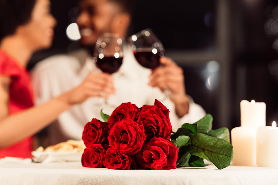 Roses Lying On Table, Unrecognizable Spouses Drinking Wine In Restaurant Photograph by Prostock-Studio