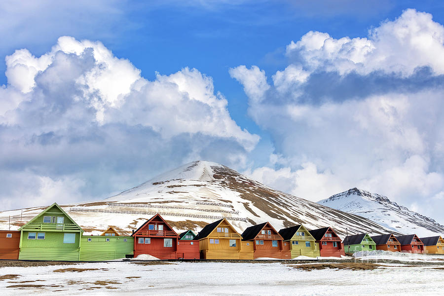 Row of colourful wooden houses in Longyearbyen, Svalbard, the most northerly town in the world. Early spring scene with snow on the mountains and the foreground Photograph by Jane Rix