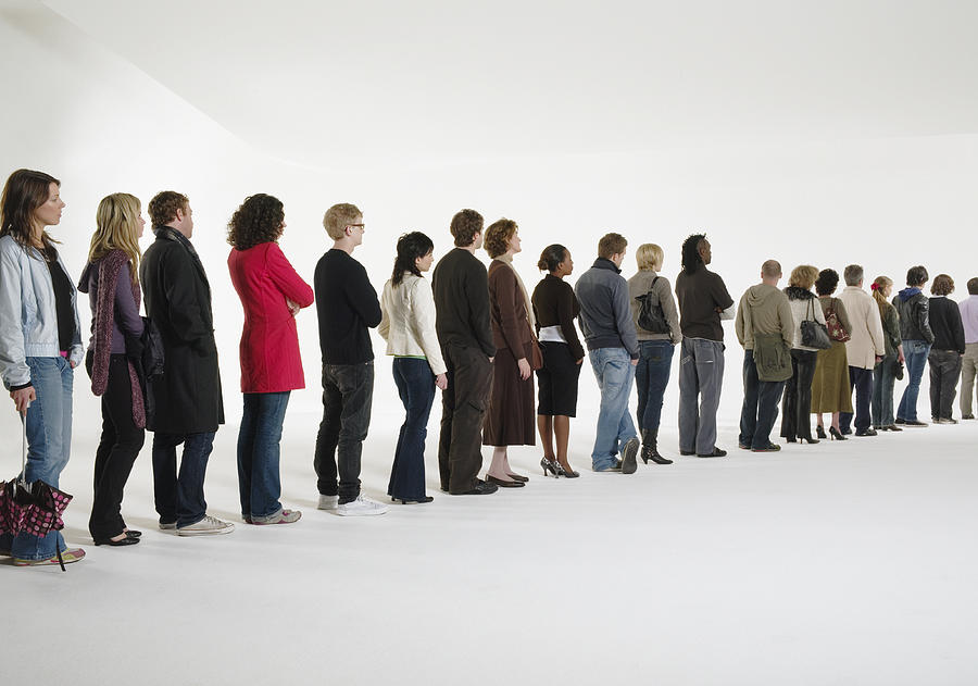Row of people standing in line, rear view (digital enhancement) Photograph by Martin Barraud