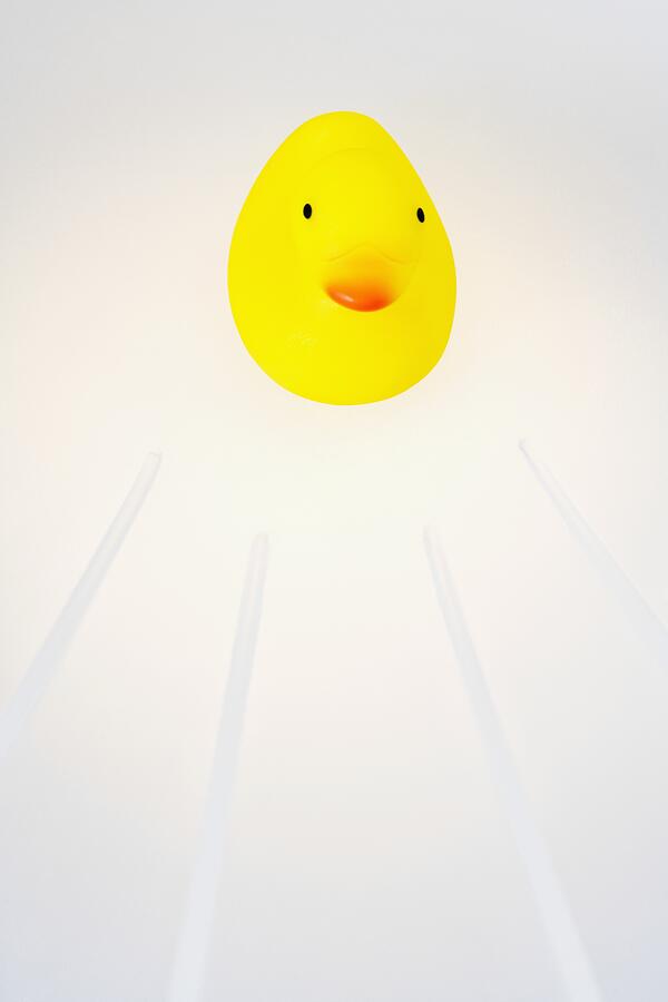 Rubber duck on a white background Photograph by Glowimages