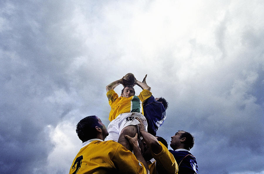 Rugby lineout jumper being supported by team-mates, low angle view Photograph by Photo and Co