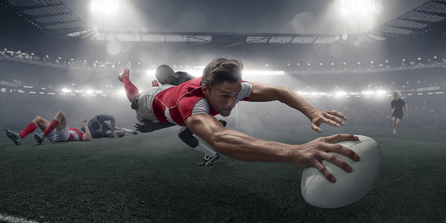 Rugby Player In Mid Air Dive With Ball To Score Photograph by Peepo