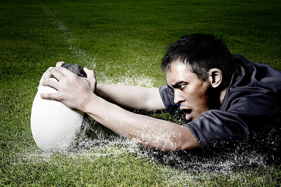 Rugby player on wet field Photograph by Image Source