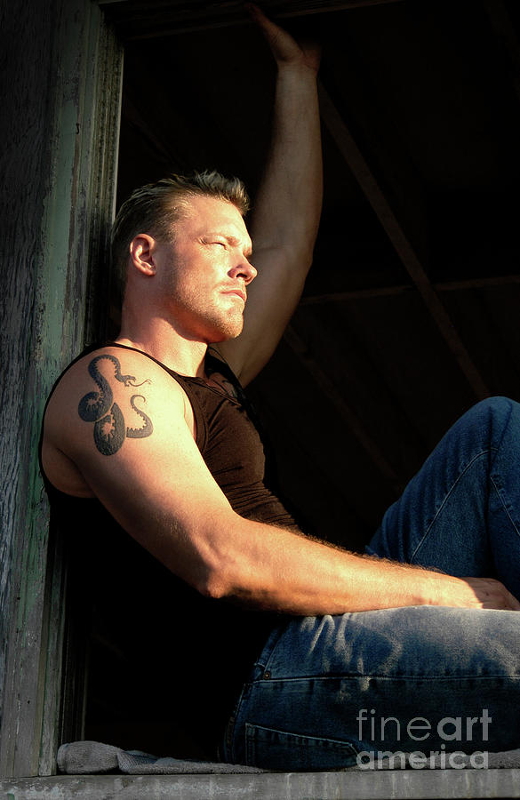 Rugged blond male model poses in the sunset glow.  Photograph by Gunther Allen