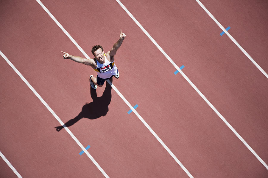 Runner cheering on track Photograph by Paul Bradbury