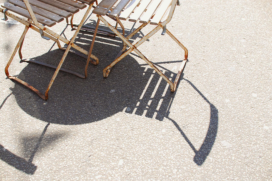 Rusty chairs and table casting shadows on ground Photograph by Lyn Holly Coorg