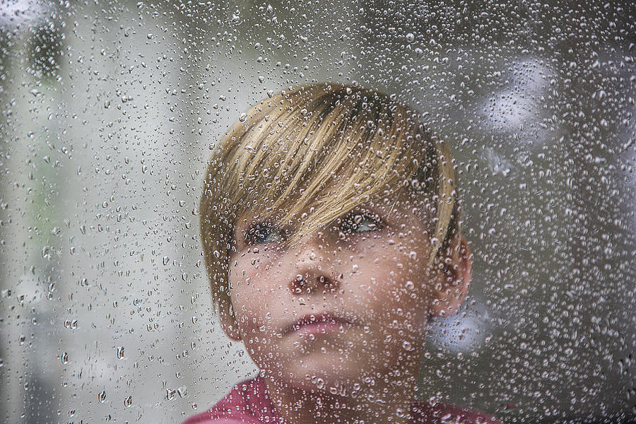 Sad 15 yr old boy looking through window. Photograph by David Trood