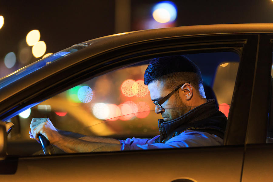 Sad man sitting in car at night Photograph by Valentinrussanov