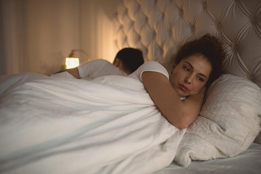 Sad woman having problems in bed with her boyfriend. Photograph by BraunS