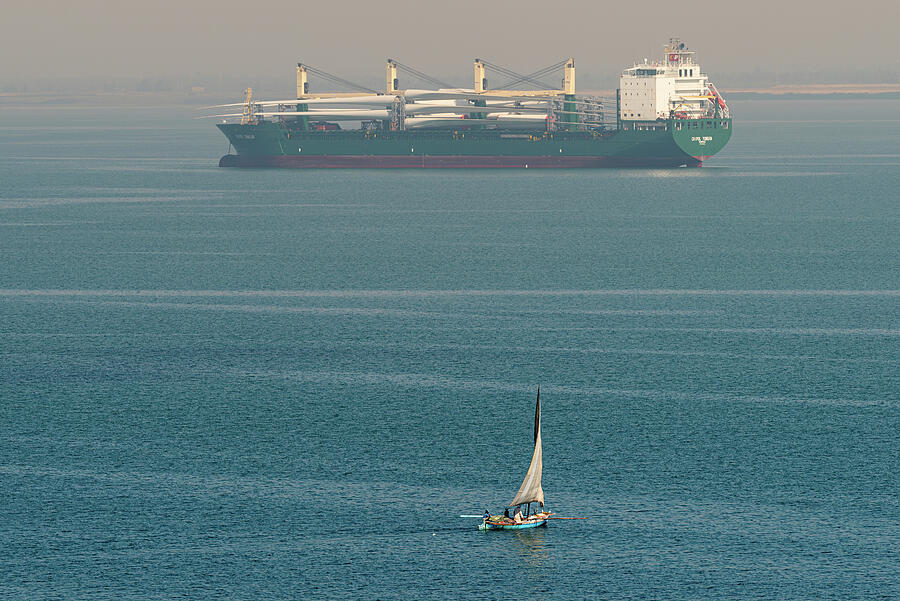 Sail Powered Fishing Boat Passing a Ship Carrying Wind Mill Blades in Great Bitter Lake Photograph by William Dickman Sail Powered Fishing Boat Passing a Ship Carrying Wind Mill Blades in Great Bitter Lake Photograph by William Dickman