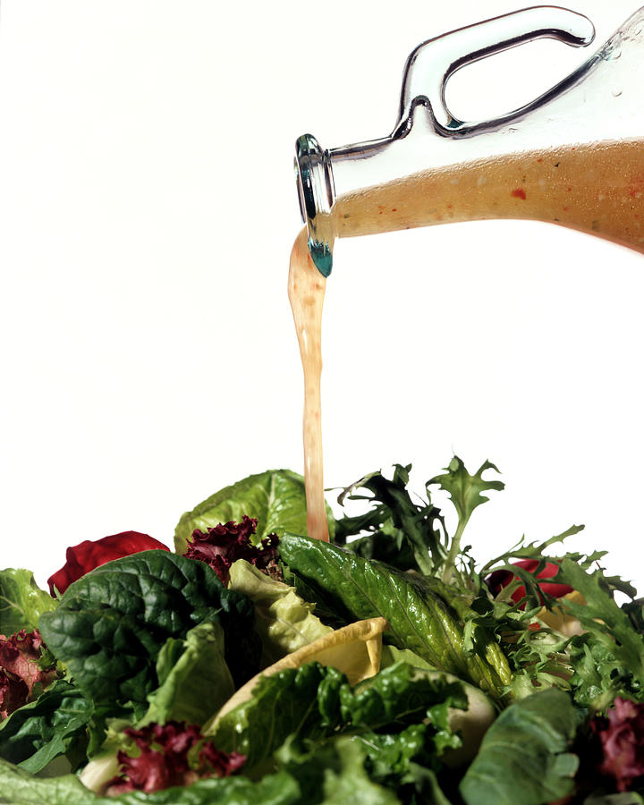 Salad greens with vinaigrette dressing Photograph by Brian Hagiwara
