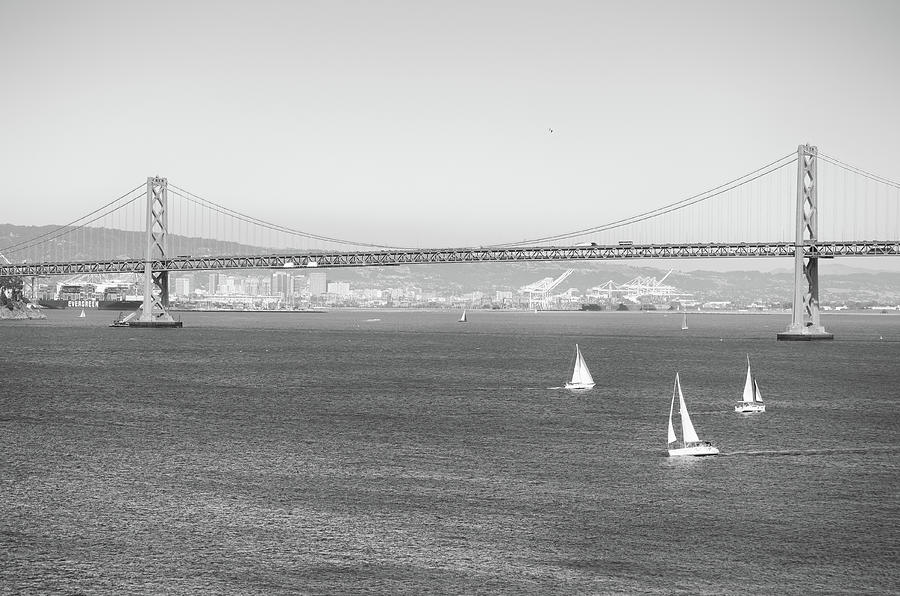 San Francisco to Oakland Bay Bridge and Sailboats Black and White Photograph by Shawn OBrien