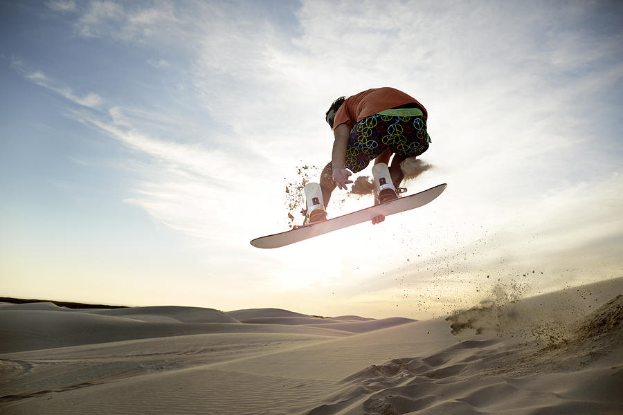 Sandboarder doing front side grab in the air Photograph by Klaus Vedfelt