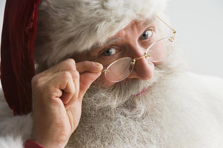 Santa Claus looking through spectacles, close-up Photograph by Jose Luis Pelaez