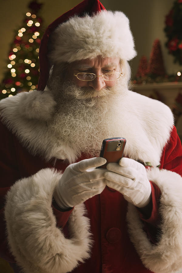 Santa Claus text messaging, close-up Photograph by Jose Luis Pelaez