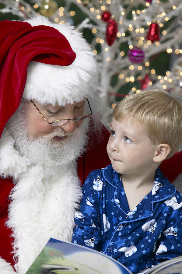 Santa Reading to a Young Boy Photograph by Digital Vision.