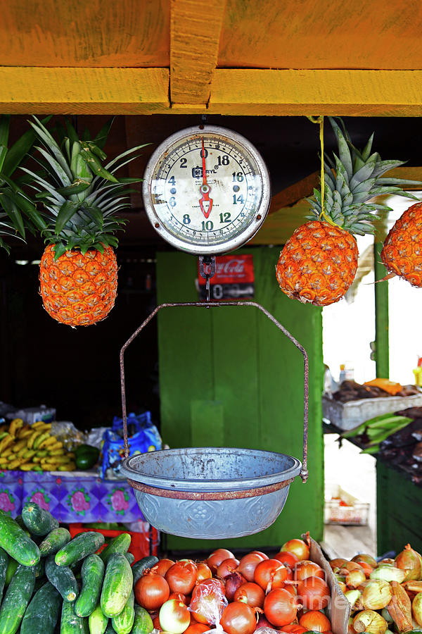 Still Life Photograph - Scales and pineapples in fruti market Panama by James Brunker