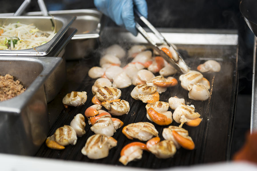 Scallops sizzling on the grills at one of the borough market stalls Photograph by Sunphol Sorakul