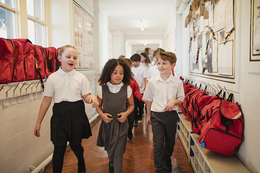 School Children Walk Through the Corridor Photograph by SolStock