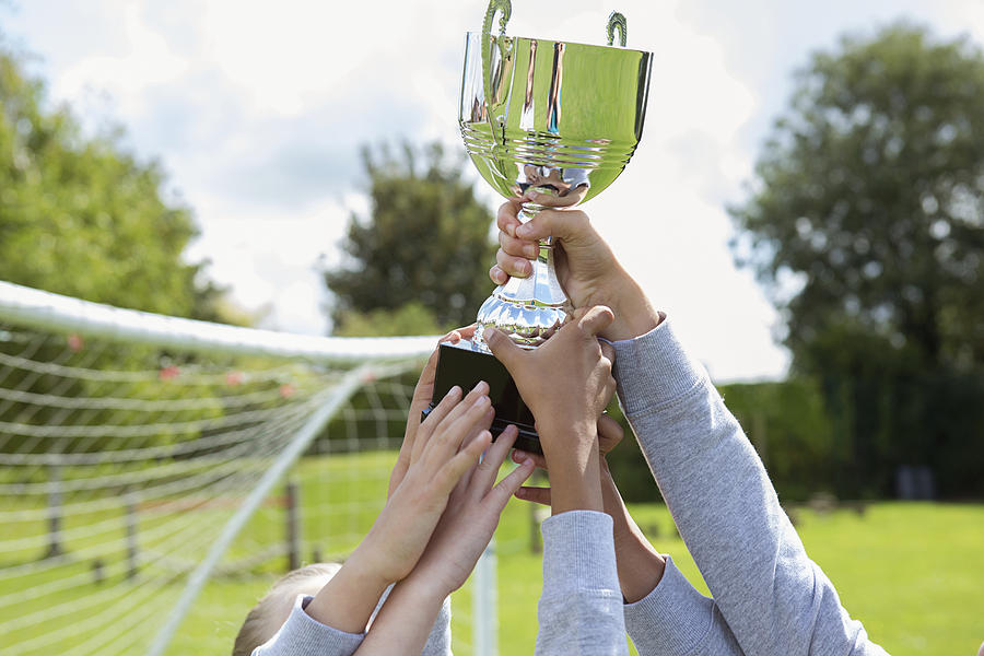 School soccer team holding trophy Photograph by Emma Tunbridge/Corbis/VCG