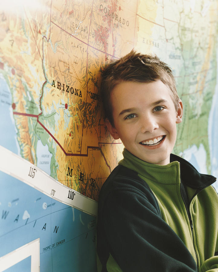 Schoolboy Standing by a Map of the USA in a Classroom Photograph by Digital Vision.