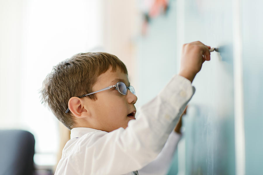 Schoolboy writing on chalk board Photograph by Tatiana Kolesnikova