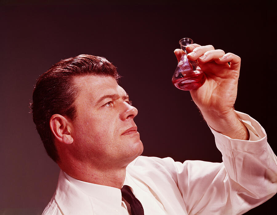 Scientific technician looking at coloured liquid in beaker. (Photo by H. Armstrong Roberts/Retrofile/Getty Images) Photograph by H. Armstrong Roberts