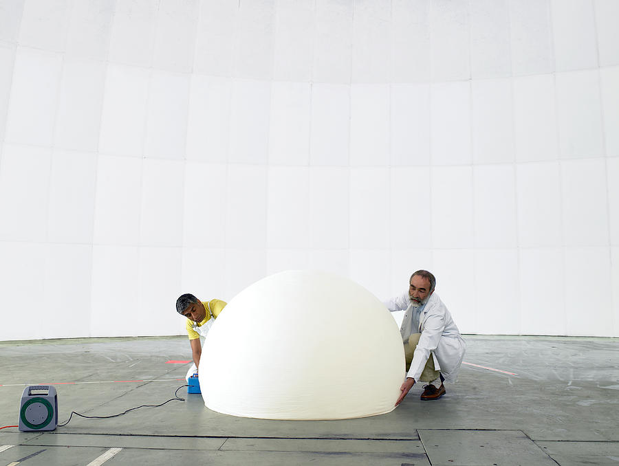 Scientist and engineer inflate weather balloon Photograph by Michael Blann