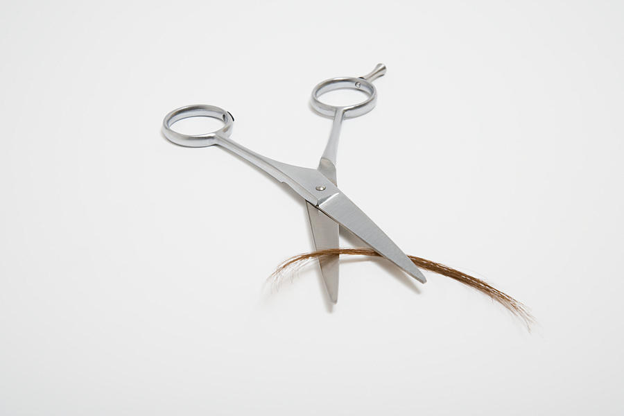 Scissors cutting hair Photograph by Image Source