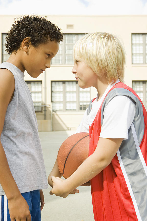 Scowling boys with basketball Photograph by Jupiterimages