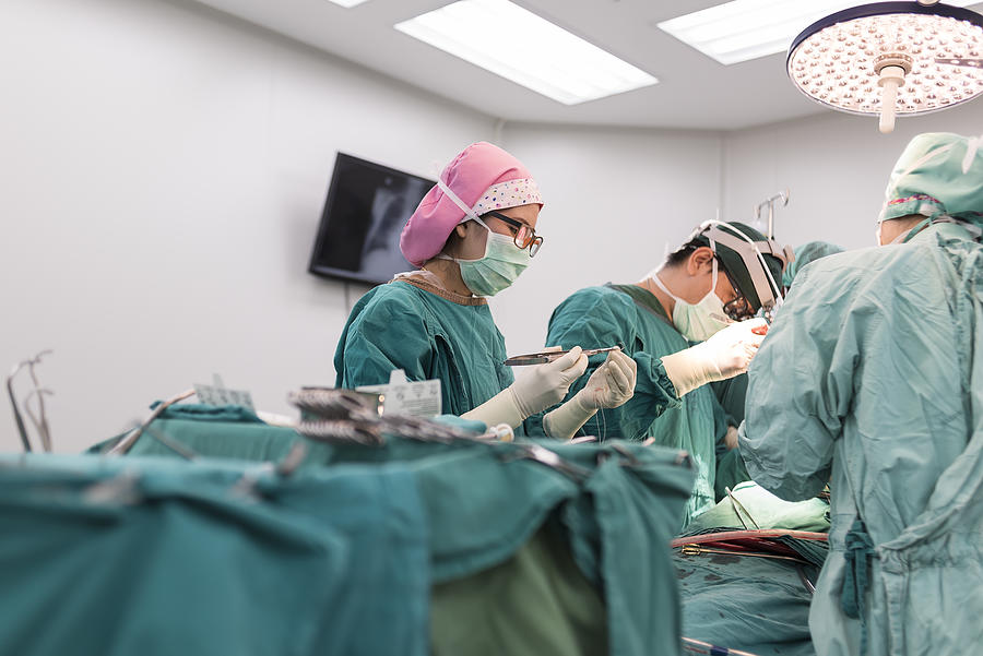 Scrub nurse prepare suture for surgeon Photograph by ChaNaWiT