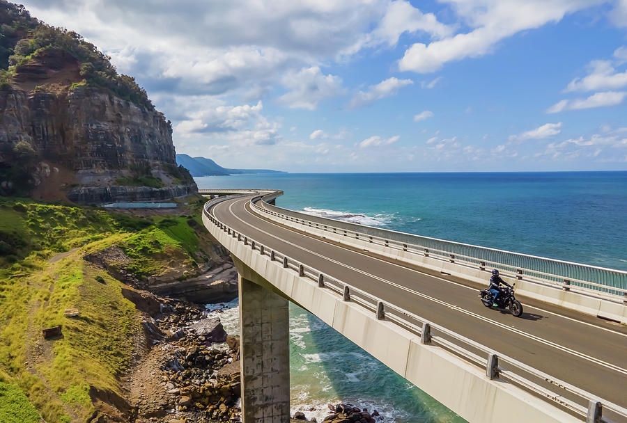 Sea Cliff Bridge and a Lone Biker Photograph by Andre Petrov