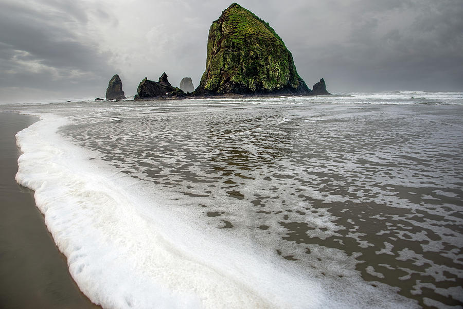 Seafoam at Cannon Beach Photograph by Jerry Cahill